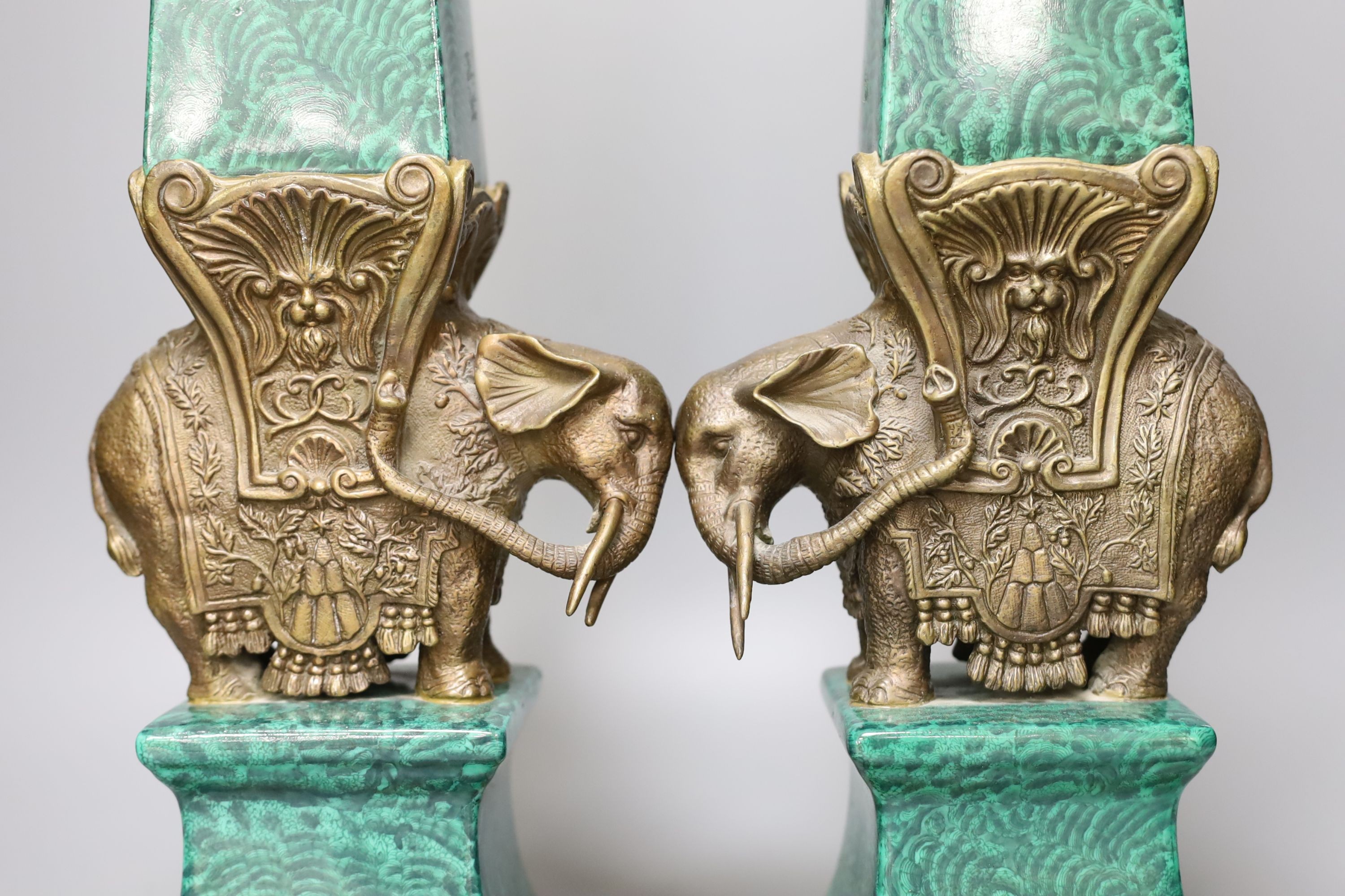 A decorative pair of faux malachite ‘elephant’ obelisks 65cm tall